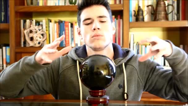 若い男の水晶球を見ることによって未来を予測 — ストック動画