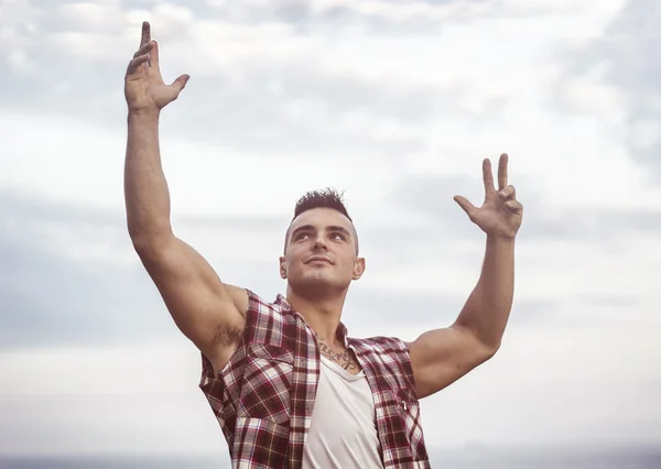 Successful sexy muscular man with hands raised — Stock Photo, Image