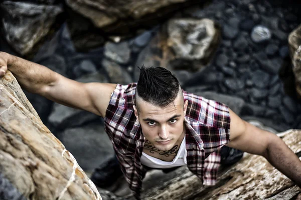 Schöner Mann, ein Kletterfelsen am Fluss — Stockfoto