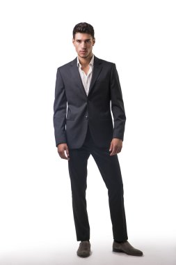 Genç işadamı kendinden emin bir şekilde beyaz üzerinde poz veriyor.