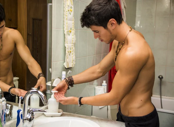 Young man putting soap on his hands — Stock Photo, Image