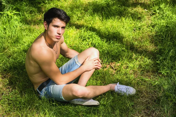 Fit handsome young man relaxing lying on lawn grass — Stock Photo, Image