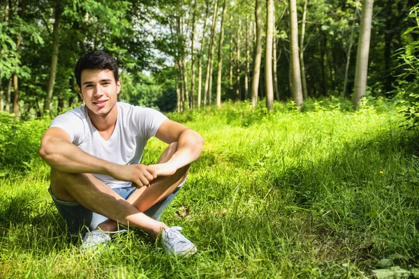 芝生の草の上に横たわるリラックス フィットのハンサムな若い男 — ストック写真