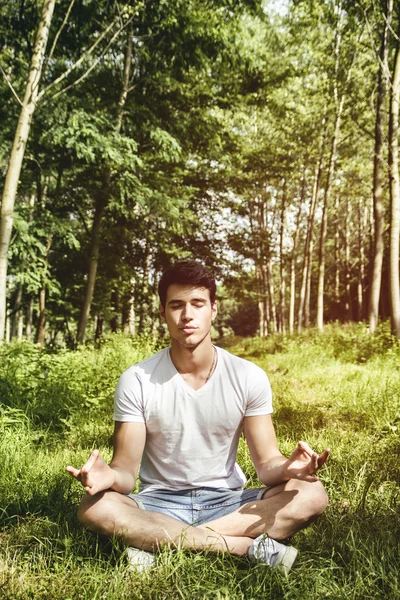 Jovem meditando ou fazendo exercícios de ioga ao ar livre — Fotografia de Stock