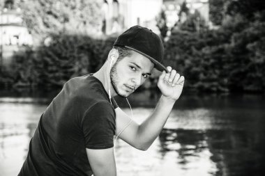 Nehir kenarında oturan düşünceli genç adam