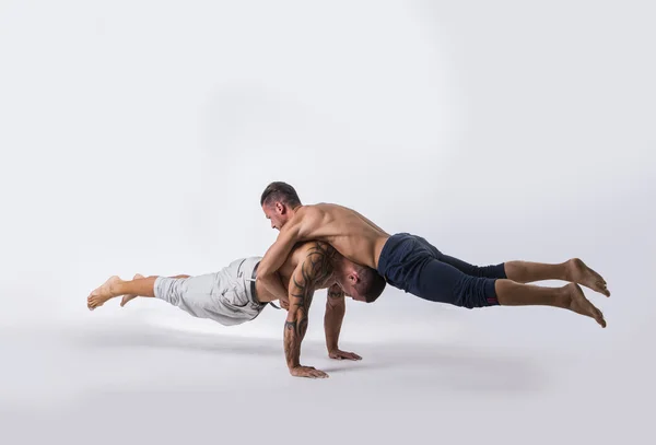 Dançarinos do sexo masculino acrobáticos balanceamento em estúdio — Fotografia de Stock