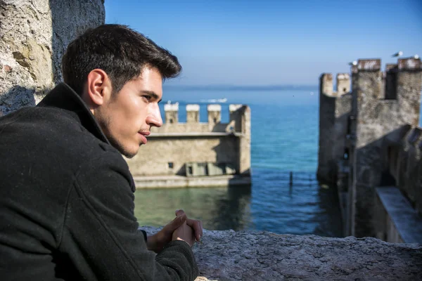 Jeune homme dans un château historique sur le lac de garde à Sirmione, Italie — Photo