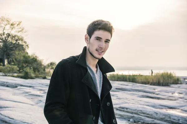 Bir güneşli bir göl üzerinde çekici bir genç adam — Stok fotoğraf