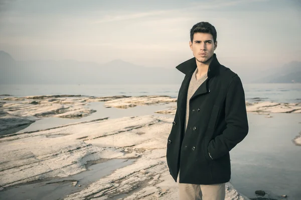 Attractive young man on a lake in a sunny - Stock-foto