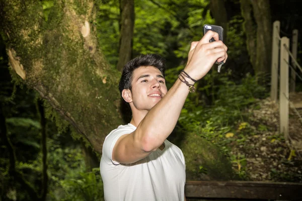 Jeune homme Selfie prise avec téléphone portable dans la forêt — Photo