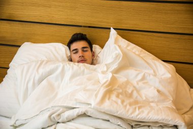 Onun yatakta uyuyan yalnız yalan yakışıklı erkek modeli