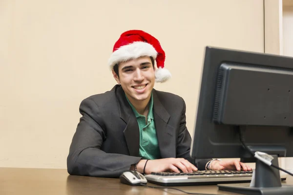 サンタ クロースの赤い帽子の青年実業家の笑みを浮かべてください。 — ストック写真
