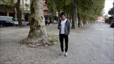 Şehir Parkı kulaklıklar müzik dinlemek içinde yürüyen genç adam