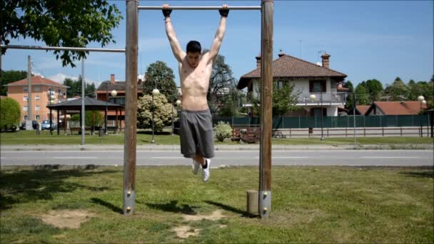 Atractivo joven sin camisa haciendo ejercicio al aire libre — Vídeo de stock