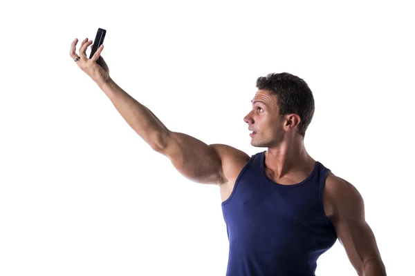Красивый мускулистый молодой человек, делающий селфи с сотовым телефоном — стоковое фото