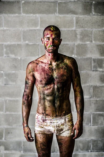 Séduisante jeune homme avec peau peintes avec des couleurs holi — Photo