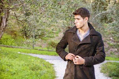 Handsome athletic young man hiking in park