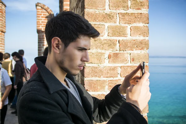 Jeune homme prenant la photo avec le téléphone cellulaire du paysage — Photo