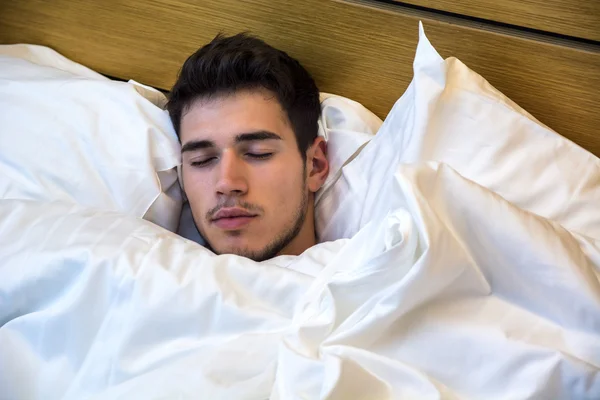 Beau modèle masculin se trouvant seul sur son lit de couchage — Photo