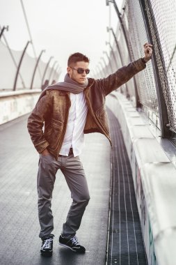 Bir köprü üzerinde duran, aşağı bakıyor trendy yakışıklı