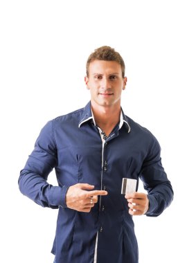 Kameraya bakarak, kredi kartı tutan çekici genç adam