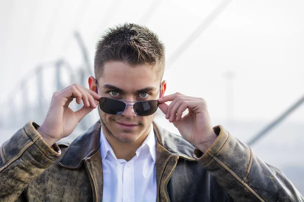 Snygg trendig man står på en trottoar — Stockfoto