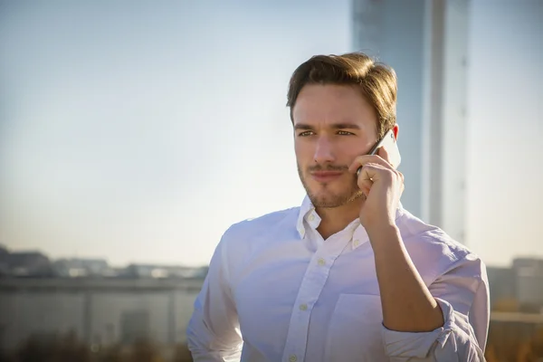 Knappe man van de trendy talkiing op mobiele telefoon, buiten — Stockfoto