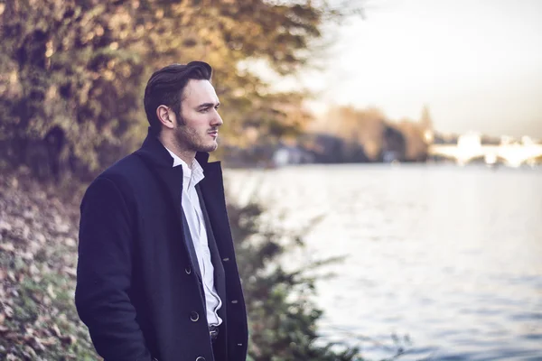 Young man outdoor in winter by lake or river — Stock Photo, Image