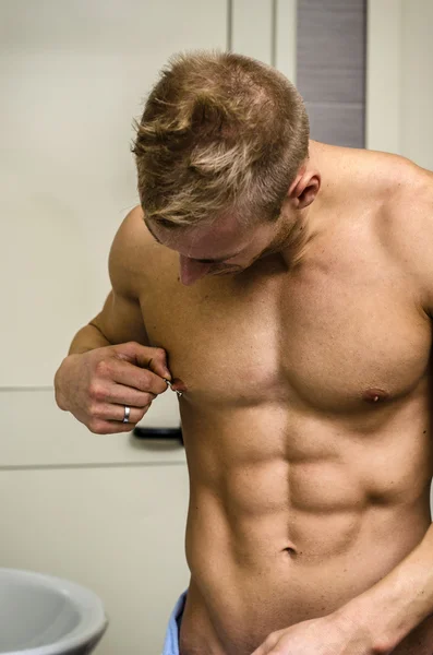 Muskulösen jungen Mann berühren, Brustwarzenpiercing — Stockfoto