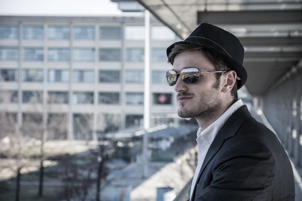 Uomo che porta il cappello e guardando fuori finestra — Foto Stock