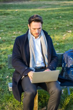 Parkta çalışan yakışıklı, zarif iş adamı.