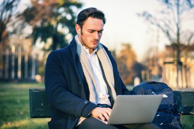 Parkta çalışan yakışıklı, zarif iş adamı.