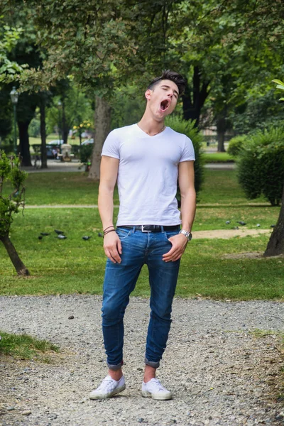 Скучно или устал молодой человек зевает — стоковое фото