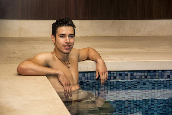 Homem jovem relaxante na piscina — Fotografia de Stock