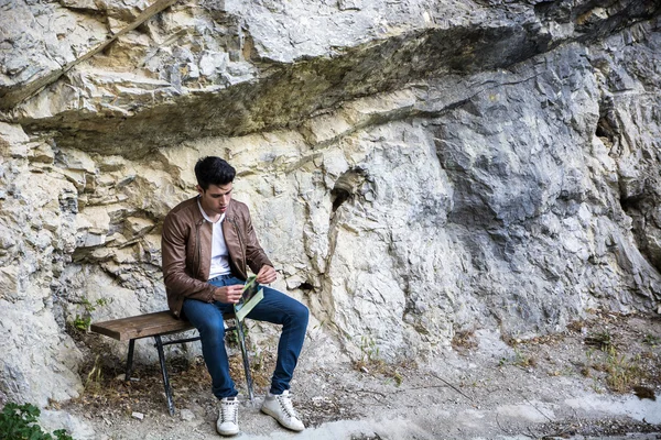 Joven sentado en el parque de la naturaleza — Foto de Stock