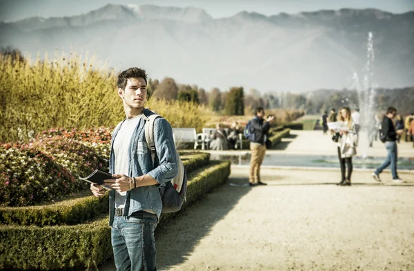 Handsome young man sightseeing in a park — Stock Photo, Image