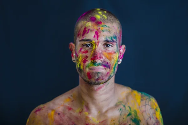 Beau jeune homme avec la peau tout peint avec des couleurs Holi — Photo