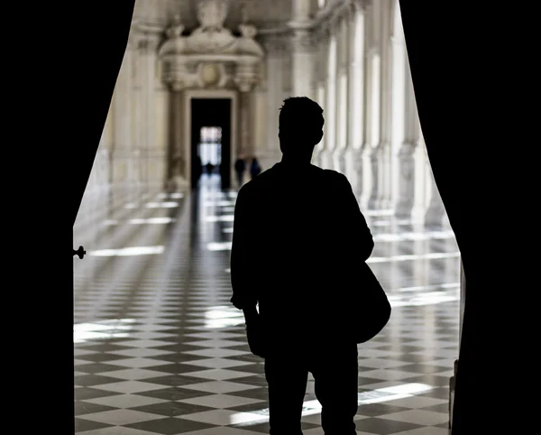 Hombre guapo con una guía dentro de un museo — Foto de Stock