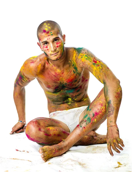 Stilig ung man med skinn alla målade med Holi färger — Stockfoto