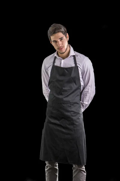 Young chef or waiter wearing black apron isolated — Stock Photo, Image