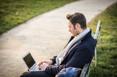 Parkta çalışan yakışıklı, zarif iş adamı.