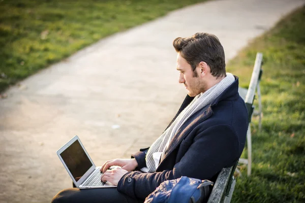 Parkta çalışan yakışıklı, zarif iş adamı.