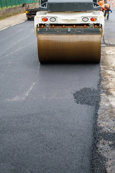 アスファルトローラーの主前輪は 道路の再建に新しいアスファルトをコンパクト化します — ストック写真