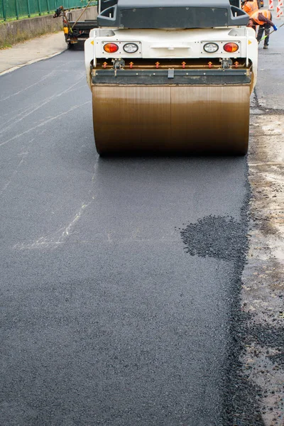 Asfalt Roller 'ın ana ön tekerleği yol yeniden inşasında yeni asfaltı sıkıştırır 