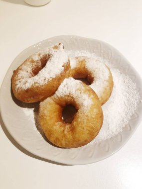 Kafede pudra şekerli lezzetli çörekler.