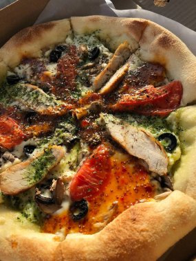 Tavuk, domates ve peynirli İtalyan pizzası. 