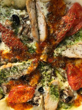 Tavuk, domates ve peynirli İtalyan pizzası. 