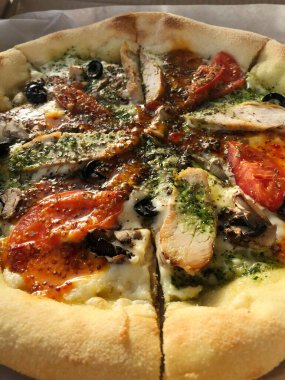 Tavuk, domates ve peynirli İtalyan pizzası. 