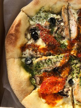 Tavuk, domates ve peynirli İtalyan pizzası. 