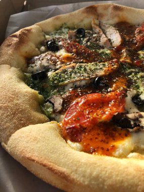 Tavuk, domates ve peynirli İtalyan pizzası. 